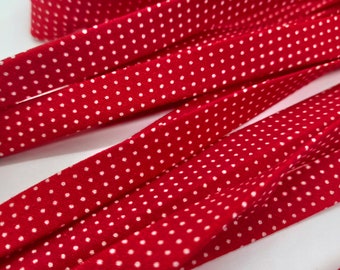 1/2 inch cotton bias tape double fold  fabric red background with tiny white pin dots. Sold by the yard. Cut after order placed.