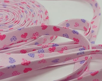 Pastel Hearts on pink 1/2 inch cotton bias tape.  Sold by the yard. Cut after order placed.