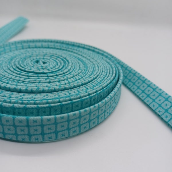 1/2 inch cotton bias tape double fold  fabric 2 shades of aqua print. Sold by the yard. Cut after order placed.