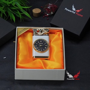 May include: A white and gold lighter with a watch face on the front. The lighter is in a white box with orange satin lining. The box has the words "LIGHTER CLASSIC AND RELIABLE" printed on the side. The box also has the words "Powerful Flame" printed on the bottom.