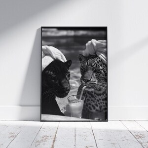 May include: Black and white photo of two leopards wearing white towels on their heads, sitting next to each other and drinking from a glass with a straw.