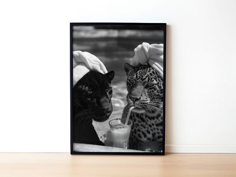 May include: Black and white photo of two animals, a black panther and a leopard, wearing white towels on their heads. They are both drinking from a glass with a straw.