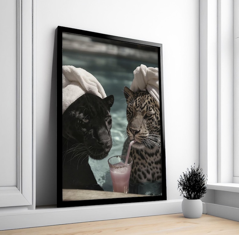 Peut inclure: Impression d'art encadr&eacute;e repr&eacute;sentant une panth&egrave;re noire et un l&eacute;opard dans une piscine, partageant une boisson rose avec une paille. La panth&egrave;re noire est &agrave; gauche, le l&eacute;opard &agrave; droite, tous deux avec des serviettes blanches. L'image est dans un cadre noir.