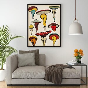 May include: A framed art print featuring whimsical illustrations of mushrooms with human-like legs. The mushrooms have colorful caps in shades of red, yellow, blue, and brown. The artwork is displayed on a neutral background.