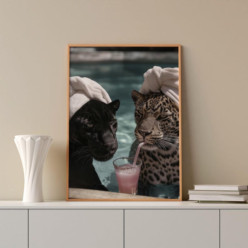 Peut inclure: Impression encadr&eacute;e repr&eacute;sentant deux grands f&eacute;lins, une panth&egrave;re noire et un l&eacute;opard, se relaxant dans une piscine. Les deux animaux portent des serviettes blanches sur la t&ecirc;te. Le l&eacute;opard boit une boisson rose.