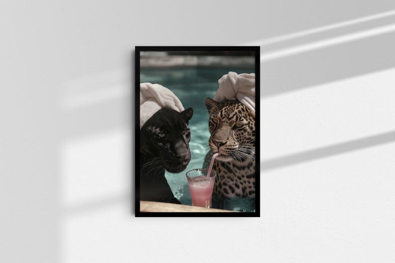 Peut inclure: Impression d'art encadr&eacute;e repr&eacute;sentant une panth&egrave;re noire et un l&eacute;opard dans une piscine, chacun avec une serviette sur la t&ecirc;te. Le l&eacute;opard boit une boisson rose avec une paille. L'&oelig;uvre est affich&eacute;e sur un mur blanc.