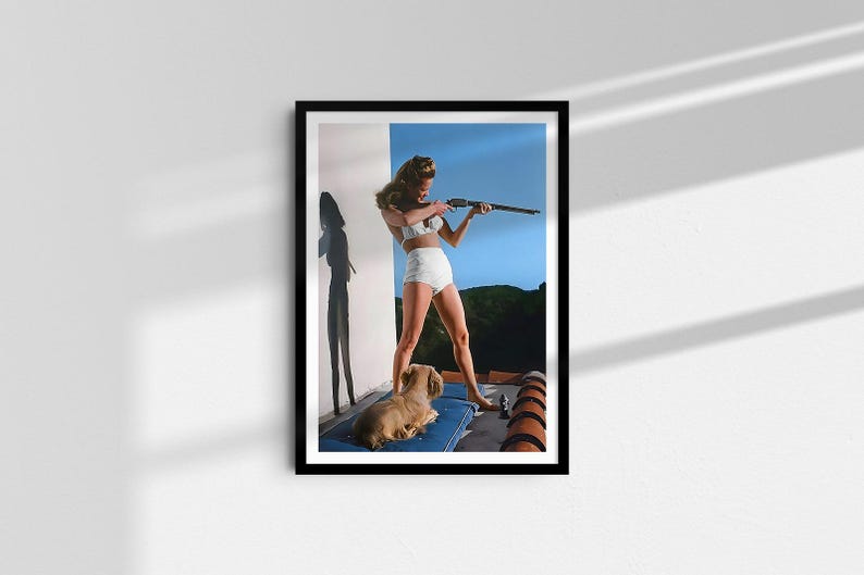 May include: A woman in a white swimsuit holds a rifle and aims it towards the right side of the frame. She is standing on a rooftop with a small dog lying at her feet. The background is a blue sky with some trees in the distance.