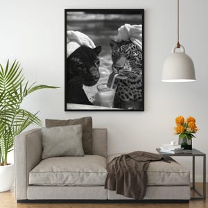 May include: Black and white photo of two panthers wearing white towels on their heads, sitting next to each other and drinking from a glass with a straw.