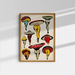 May include: A framed art print featuring whimsical illustrations of mushrooms with human-like legs. The mushrooms have various cap colors, including red, yellow, and blue, and are set against a cream-colored background.