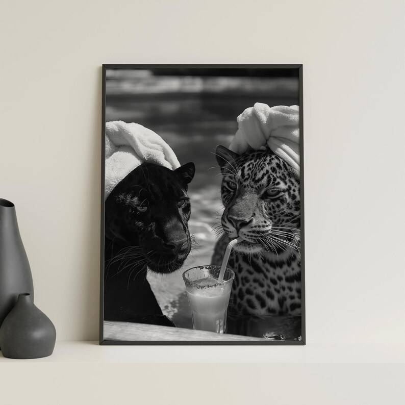 May include: Black and white photo of two leopards wearing white towels on their heads, one is drinking from a glass with a straw.