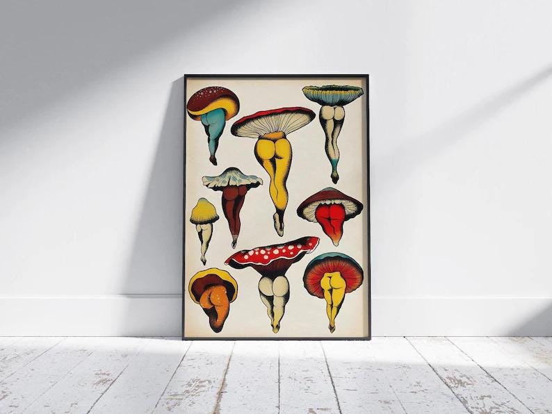 May include: A framed art print featuring whimsical mushroom illustrations. The mushrooms have colorful caps and are depicted with legs and buttocks. The artwork is displayed against a neutral background, with a black frame.