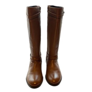 Puede incluir: Un par de botas altas de cuero marr&oacute;n. Cada bota presenta una correa decorativa y detalles de hebilla alrededor del tobillo y la pantorrilla. Las botas tienen una punta redondeada y un tac&oacute;n bajo.