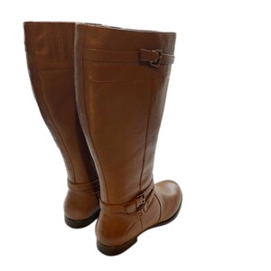 Puede incluir: Un par de botas altas de cuero marr&oacute;n. Las botas tienen hebillas en el tobillo y en la parte superior. Est&aacute;n hechas de cuero liso, adecuadas para diferentes conjuntos.
