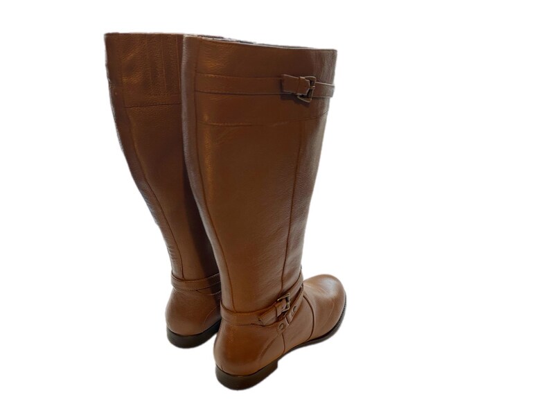 Puede incluir: Un par de botas altas de cuero marr&oacute;n. Las botas tienen hebillas en el tobillo y en la parte superior. Est&aacute;n hechas de cuero liso, adecuadas para diferentes conjuntos.