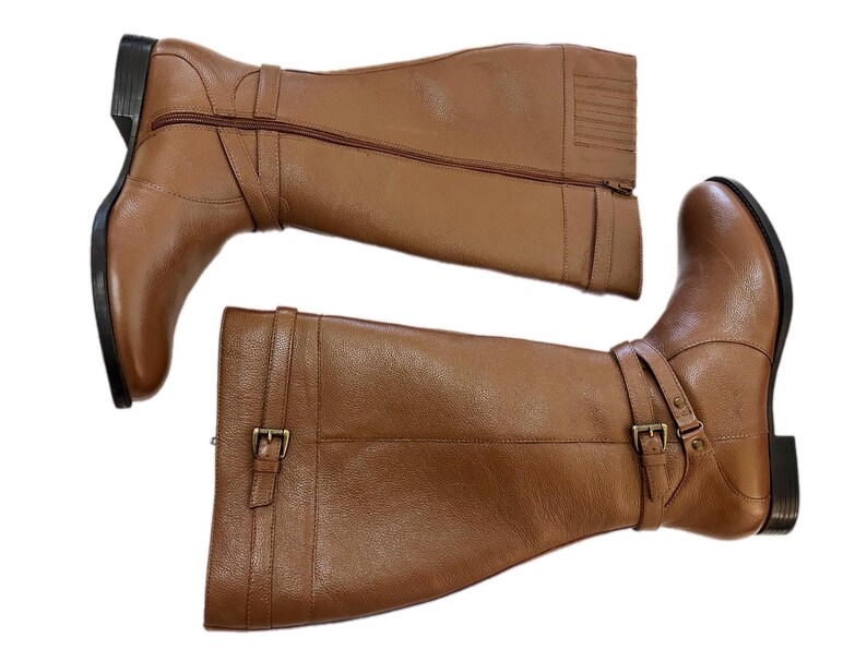 Puede incluir: Un par de botas altas de cuero marr&oacute;n. Las botas tienen una cremallera lateral, una correa con hebilla y un tac&oacute;n peque&ntilde;o. Las botas son de cuero liso.