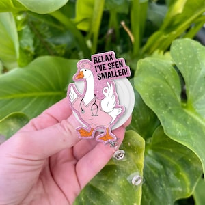 May include: A pink and white badge reel featuring a cartoon goose in a nurse's uniform, with the text "Relax I've Seen Smaller!". The goose is giving an "okay" hand gesture. The badge reel has a clear plastic retractable cord.
