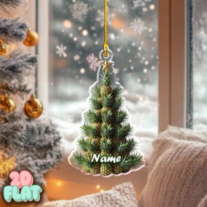 Könnte beinhalten: Ein klarer Weihnachtsbaumschmuck aus Acryl in Form eines Weihnachtsbaums aus Ananas. Der Schmuck hat einen goldenen Stern an der Spitze und eine goldene Schnur zum Aufhängen. Das Wort "Name" ist auf dem Schmuck geschrieben.