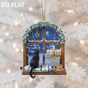 Op de afbeelding: Een 2D plat ornament met een zwarte kat die uit een raam kijkt naar een besneeuwde nachtscène. Het raam is versierd met een bloemenboog, een menora en een Davidster. De tekst "2D FLAT" staat linksboven.