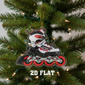 May include: A clear acrylic Christmas ornament shaped like a roller skate, with red, black, and white details. The ornament is decorated with a string of colorful lights and the text "JACKSON" is visible. The ornament is hanging on a Christmas tree.