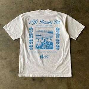 May include: White t-shirt with a blue graphic print of the NYC Running Club logo, a skyline of Manhattan, and runners in the 1989 New York Marathon. The text "Five Boroughs of New York Marathon 89'" is printed below the graphic.
