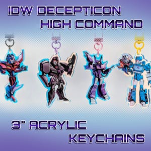 Op de afbeelding: Vier acryl sleutelhangers met Decepticon-personages van IDW High Command. Elke sleutelhanger is ongeveer 7,6 cm hoog en bevat een zilverkleurige sleutelring. De sleutelhangers zijn in verschillende kleuren, waaronder rood, blauw, paars en grijs.