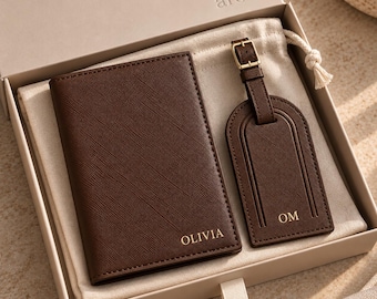 May include: A dark brown passport holder and a matching luggage tag with a gold buckle, both featuring a textured finish. The passport holder is personalized with the name OLIVIA, and the luggage tag is personalized with the initials OM.