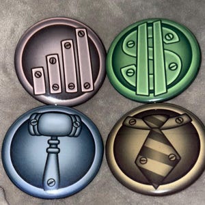 May include: Four round, metallic-looking pins. One pin features a rising bar graph, another a dollar sign, a third a gavel, and the last a striped tie. Each pin has a metallic border and is secured with small screws.
