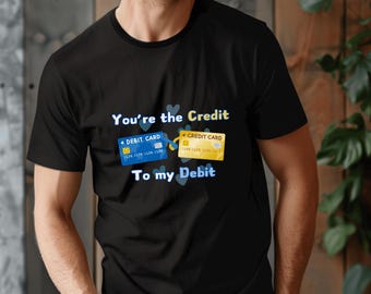 May include: A black t-shirt with a graphic of two credit cards connected by a heart. The text on the shirt reads "You're the Credit to my Debit".