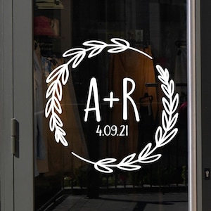May include: A white wreath with leafy branches surrounds the letters "A+R" and the date "4.09.21".