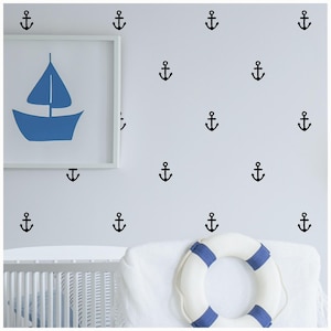 May include: A white wall with a white crib and a white throw pillow with a blue and white life preserver. The wall is decorated with black anchor decals.