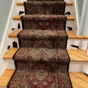 May include: A set of black rat silhouettes on a set of stairs with a patterned carpet runner. The silhouettes are placed on each step of the stairs.