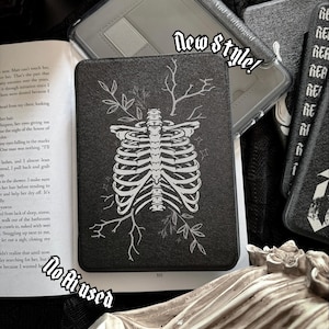 May include: A black e-reader case featuring a white line art illustration of a human rib cage surrounded by branches and small stars. The text New Style is printed in a gothic font above the case, and the text No Flused is below.