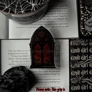 May include: A white ceramic mug with a black handle and the text "But First, Coffee" in a bold, black font. The mug is set against a blurred background, suggesting a cozy setting.