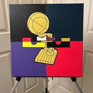 May include: A square canvas art piece depicting a basketball trophy design. The artwork is divided into four sections of black, navy blue, purple, and red. The trophy is yellow and brown, with a yellow basketball on top.