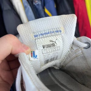 May include: Close-up of a white Puma sneaker's interior, showcasing the brand label with the Puma logo and text that reads "Not intended for riding." The label also includes size information: UK 7, US 8, EUR 40%, and CM 26.