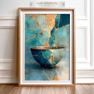 May include: Framed wall art depicting a teal bowl with gold Kintsugi detailing. The image has a textured effect, with teal and gold tones. The top of the frame has the text "wall artisticity" and "PRINTABLE WALL ART". The artwork is presented in a wooden frame.