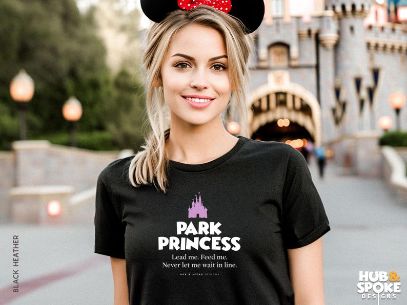 Może przedstawiać: Czarny t-shirt z r&oacute;żowym nadrukiem zamku i tekstem "Park Princess. Lead me. Feed me. Never let me wait in line."