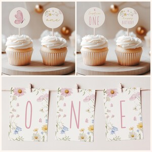 May include: A set of floral themed party decorations for a first birthday. The set includes three cupcake toppers with butterflies and the word "one" and three banner pieces with the word "one" on a floral background.