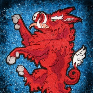 Pode incluir: Um remendo bordado que representa um javali estilizado com uma asa branca, em pé sobre suas patas traseiras com a boca aberta, sobre um fundo azul brilhante.