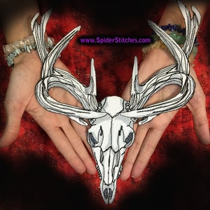 May include: White embroidered deer skull patch with antlers. The patch is on a red background.