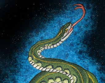 Op de afbeelding: Een groene slang met een gele streep is geborduurd op een blauwe achtergrond met witte glitter. De slang is opgerold en zijn tong steekt uit.