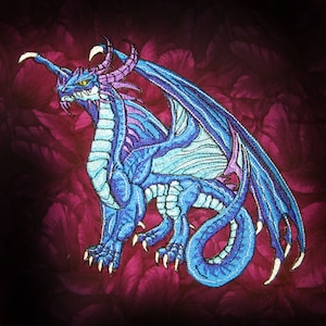 May include: A blue and purple embroidered dragon with wings outstretched. The dragon is on a dark red background with a floral pattern.