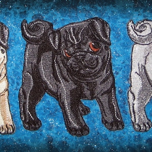 Puede incluir: Tres perros pug bordados, uno negro, uno blanco y uno marrón, sobre un fondo azul.