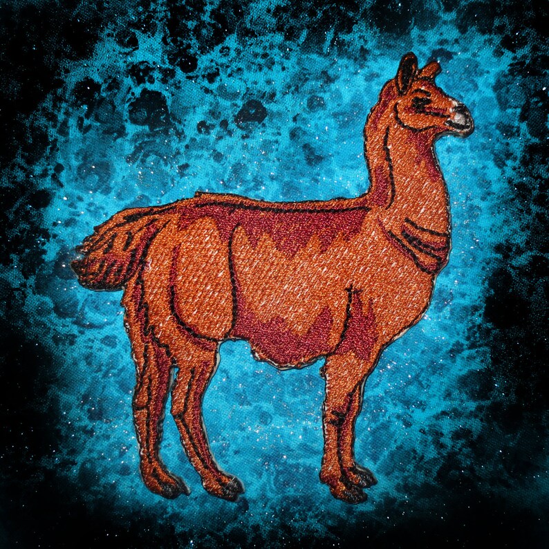 May include: Embroidered brown llama on a blue and black speckled background.