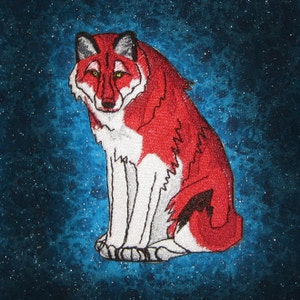 Könnte beinhalten: Ein roter und weißer Wolf mit schwarzer Nase und Augen sitzt auf einem blauen Hintergrund mit weißen Sternen.