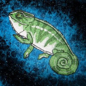 May include: A green and white chameleon with a curled tail, embroidered on a dark blue background with white speckles.