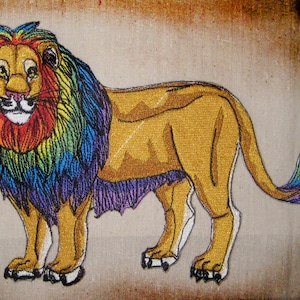 May include: Embroidered lion with a rainbow mane and tail. The lion is standing on a beige background.