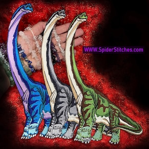 May include: Three embroidered dinosaur patches in different colors: blue, gray, and green. The patches are all the same design, but each has a different color scheme. The patches are shown on a red background.