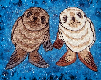 May include: Two embroidered sea lions with brown and white fur, facing each other, on a blue background with white speckles.