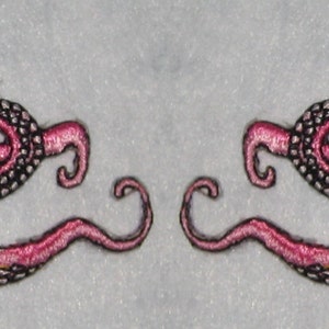 Puede incluir: Dos parches bordados de pulpo rosa con contornos negros. El pulpo tiene ocho tentáculos, algunos de los cuales están enroscados.